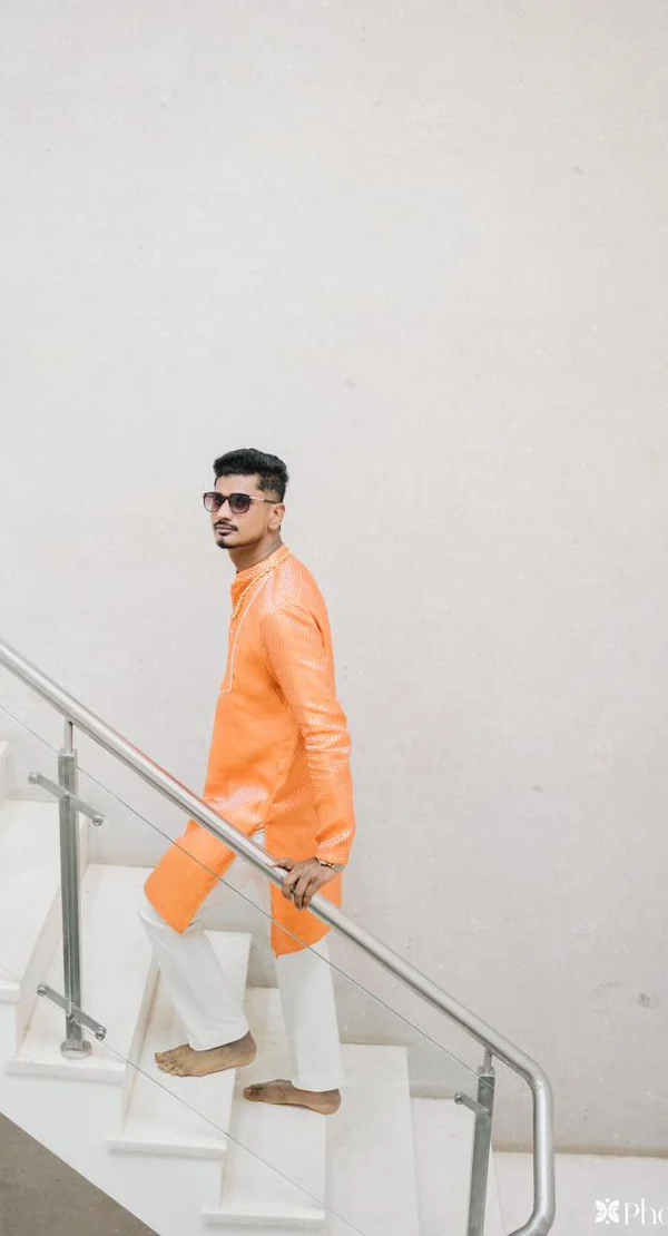 A client in an orange kurta and white churidar